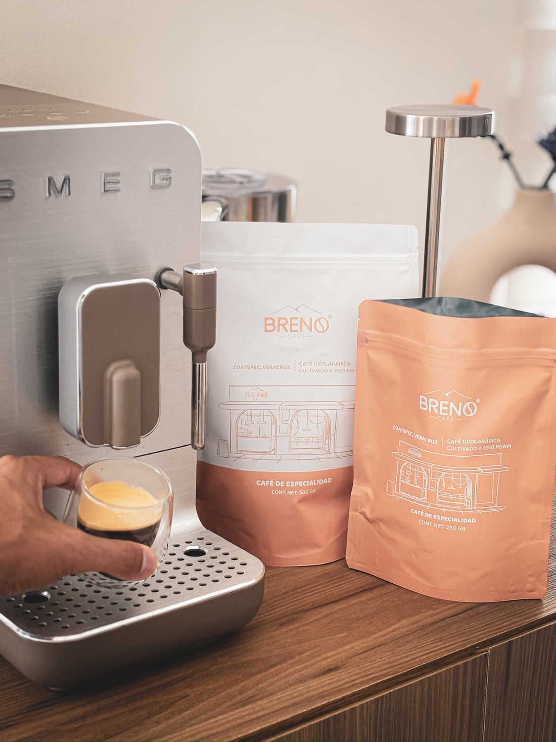 Taza de espresso con Café Breno y bolsas de 500 g y 250 g
